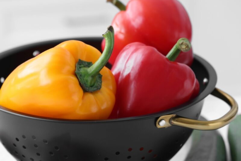 Fresh bell peppers in black colander