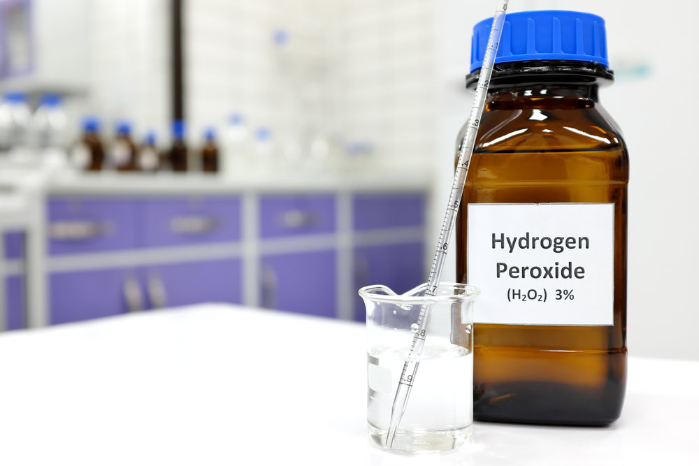 Hydrogen Peroxide bottle beside a beaker