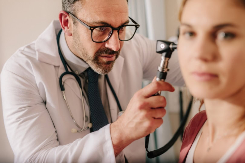 Ear doctor checking a patient for mites