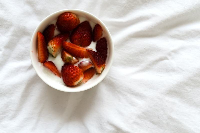 Slices of Strawberries with yougurt in White Bowl