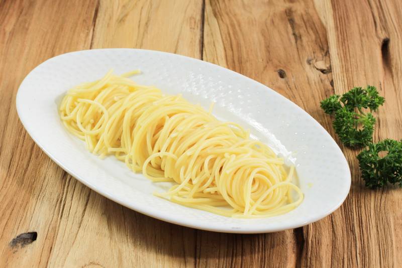 Spaghetti Pasta in a Oval White Plate Isolated on Wooden Background