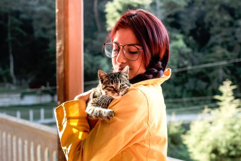 a young lady carrying a cat
