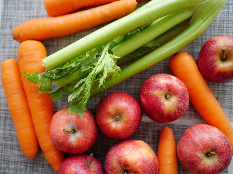 celery, apples and carrots on a table
