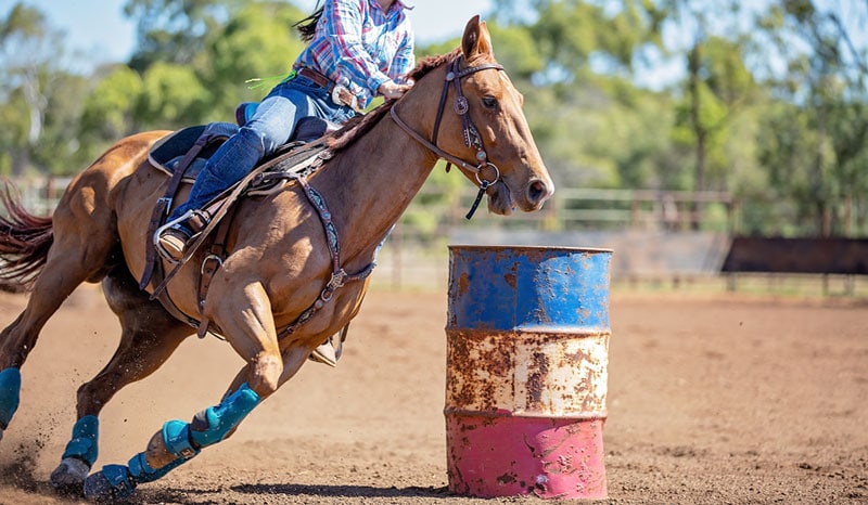 close up of cowgirl with her horse in a barrel racing event