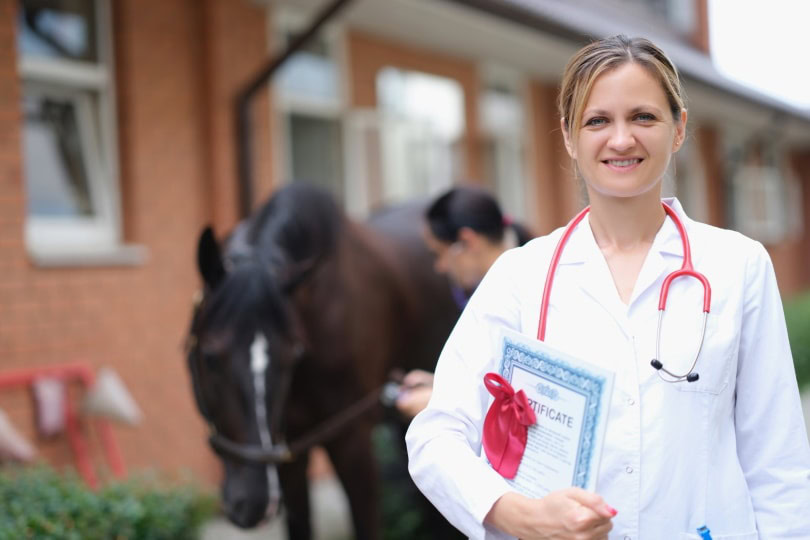 female vet. holding certificate