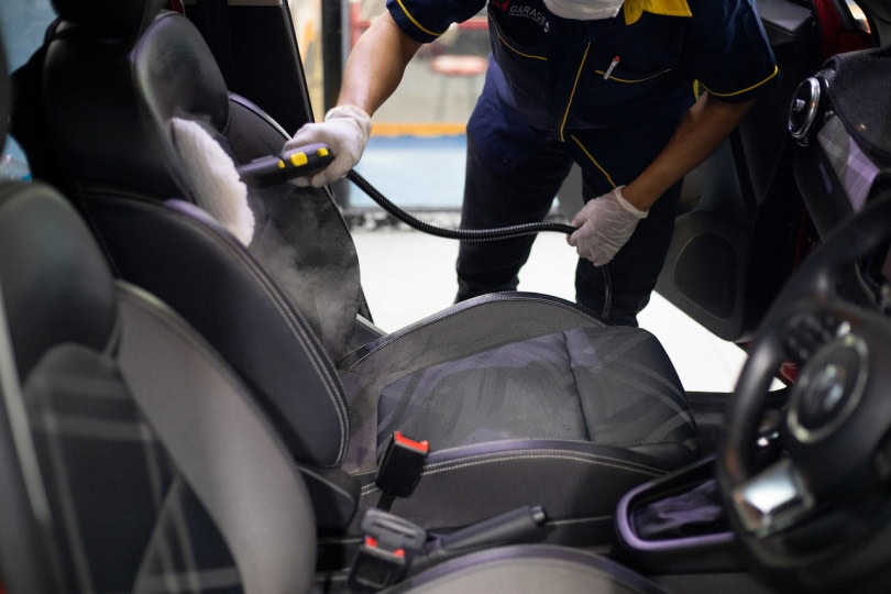 man cleaning car seat