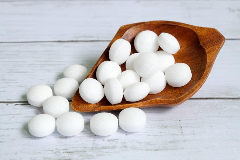 mothballs naphthalene balls on wooden scoop