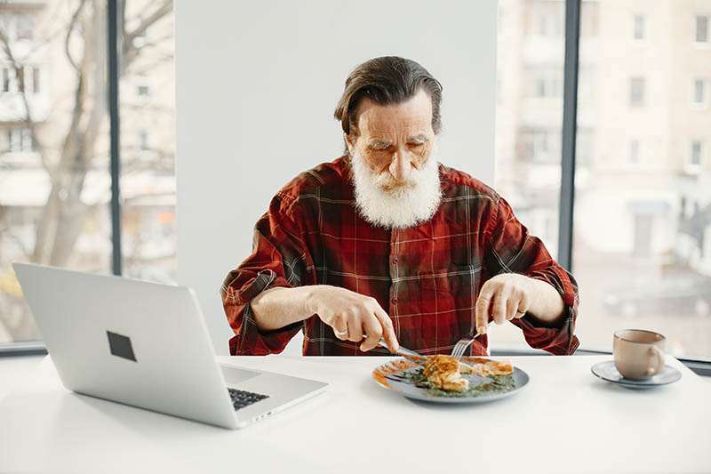old man in checkered long sleeve eating