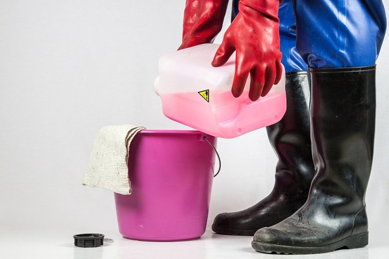pouring corrosive cleaner into the bucket