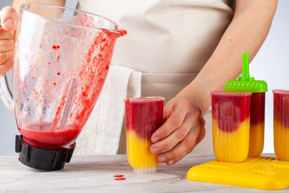 preparing homemade all natural fruit popsicles