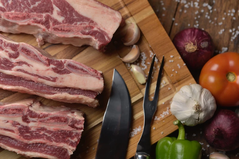 slabs of pork meat beside knife and spices