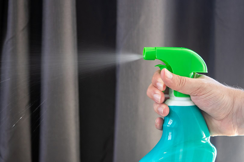 spraying a cat repellant in the house