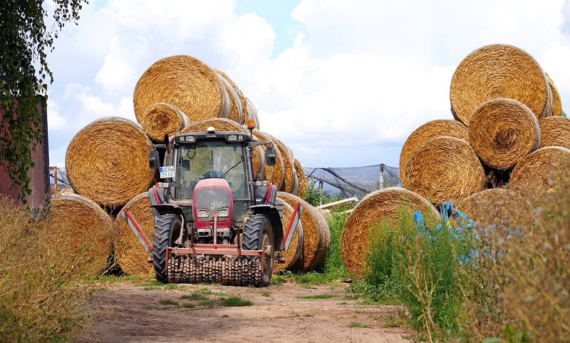 tractor working on bales of hay