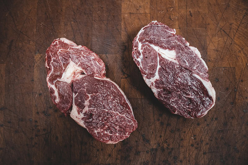 two slabs of meat on the wooden table