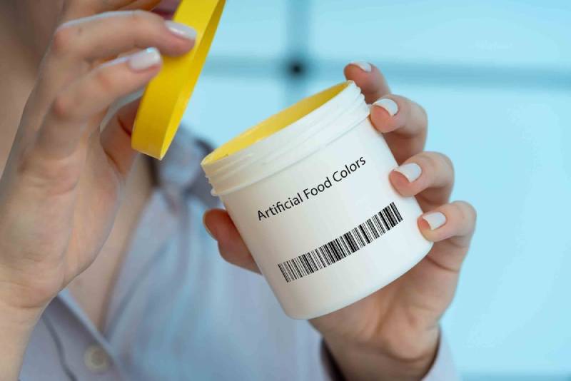 woman opening a bottle of artificial food color or dye