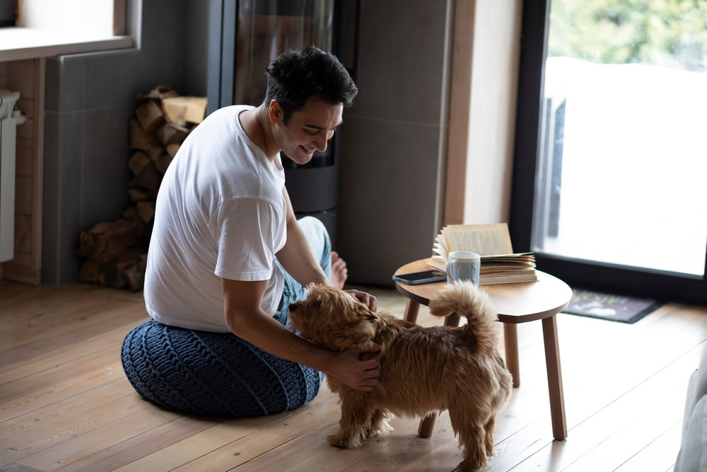 young man petting his small dog